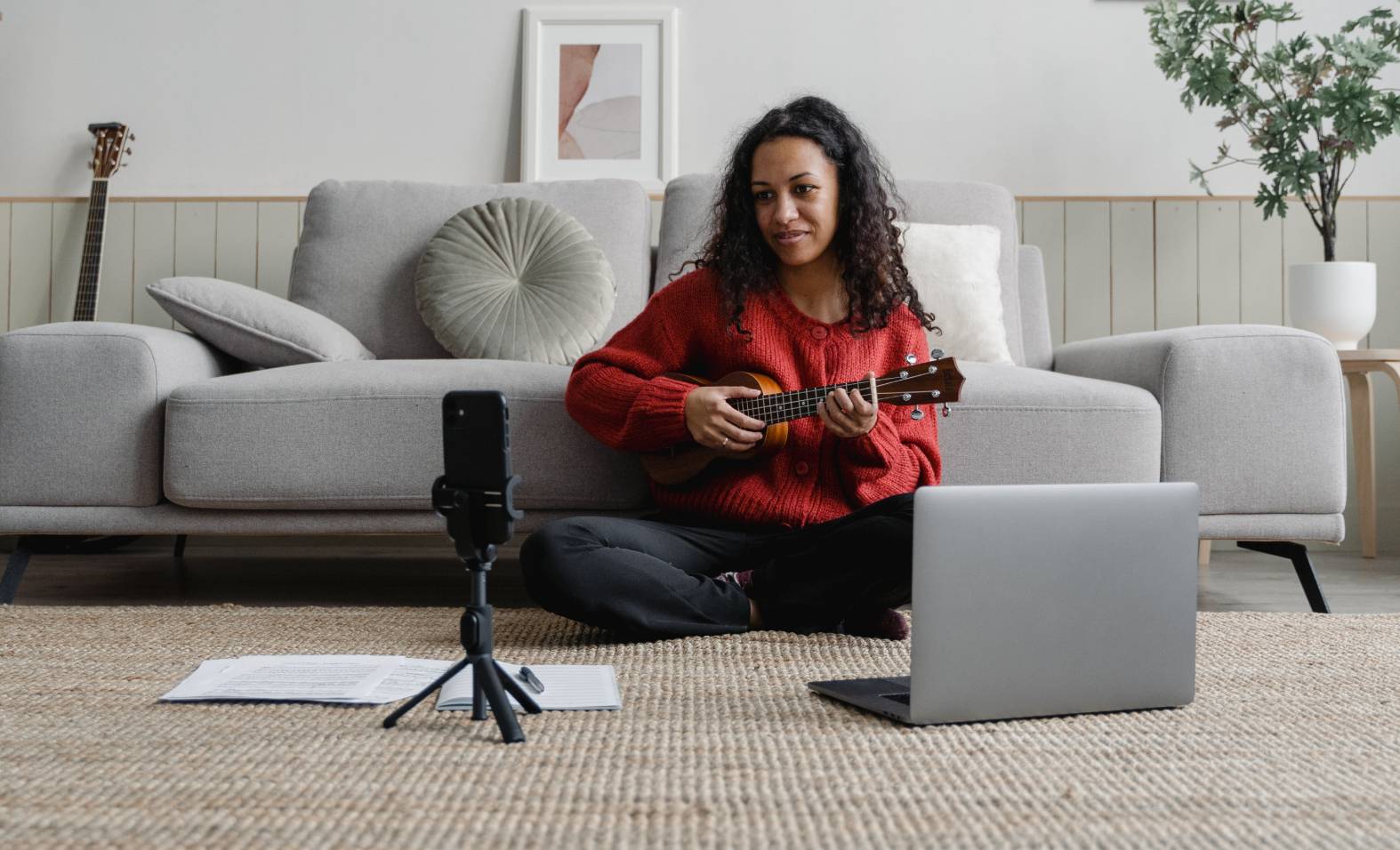 woman filming herself playing guitar