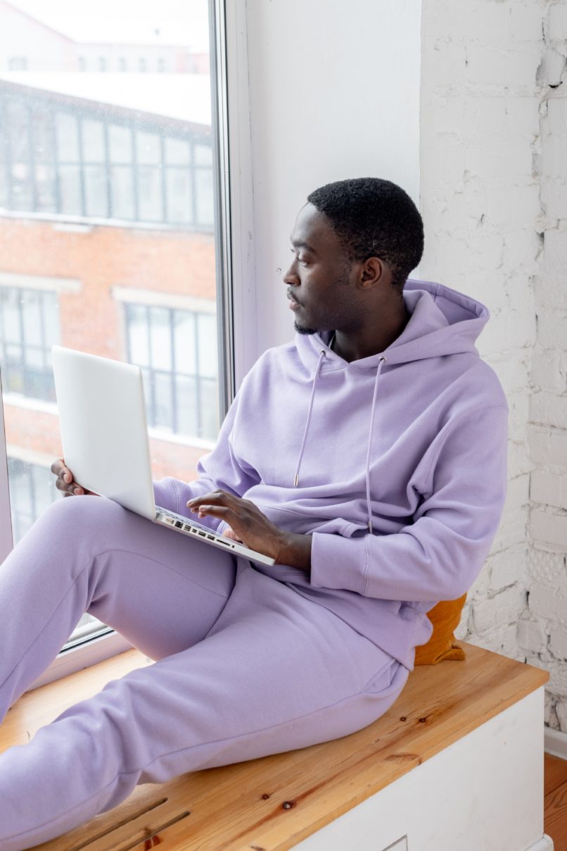 man on laptop looking out window