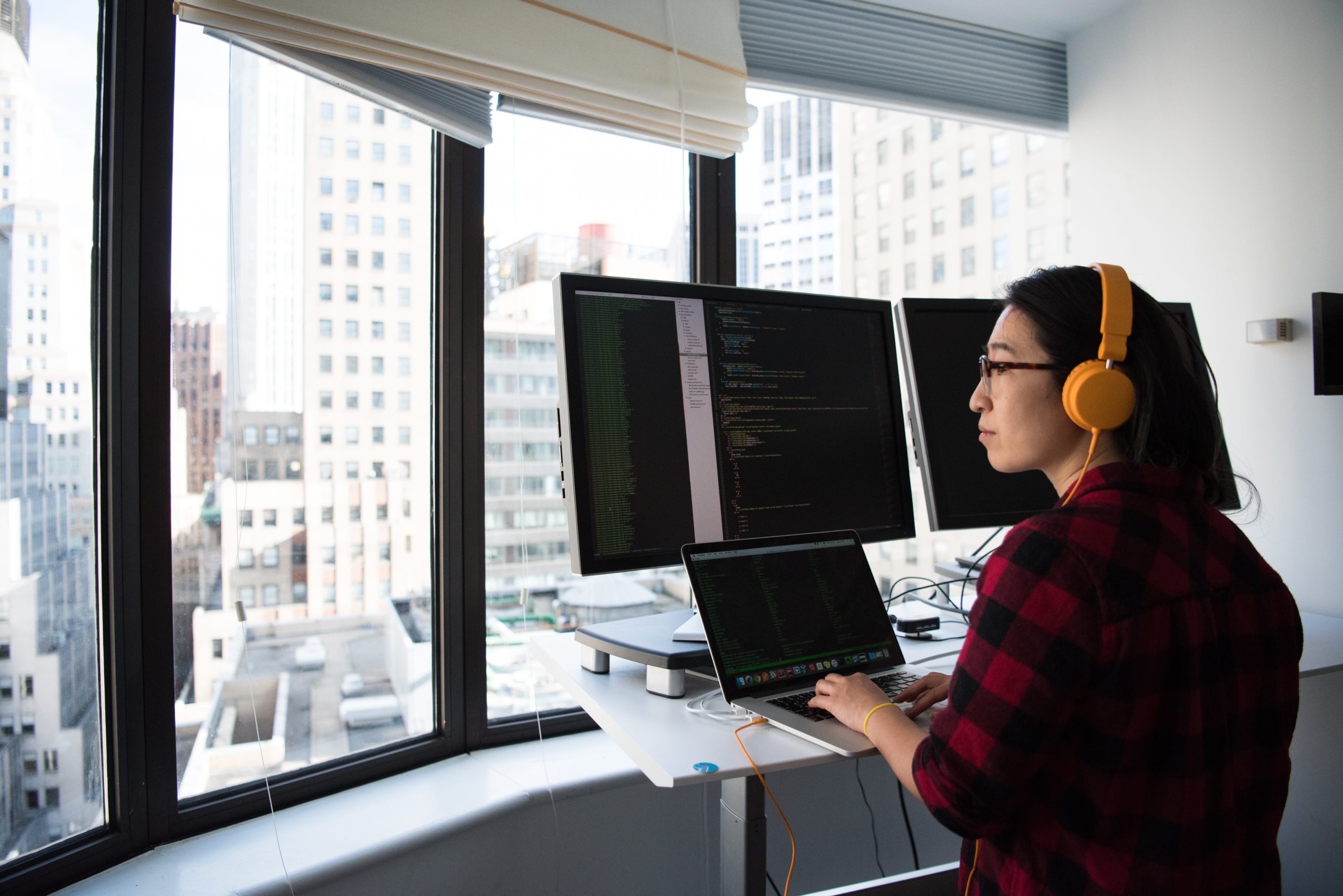 woman on computer with headphones