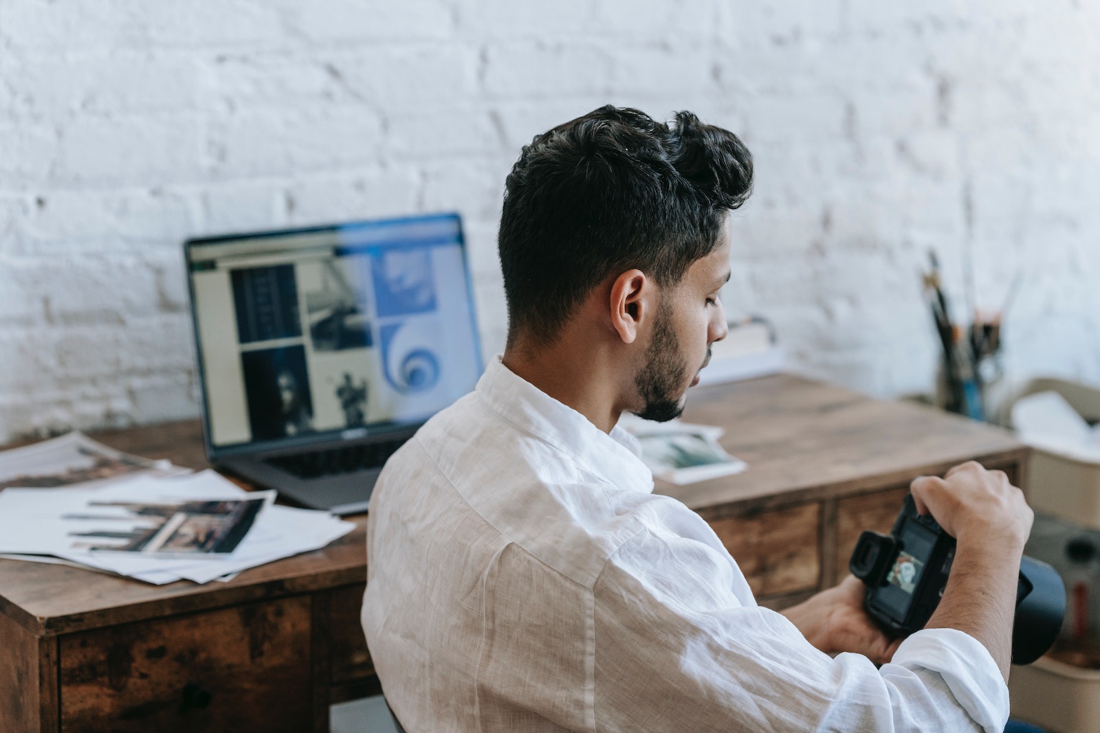 man viewing digital camera while at desk