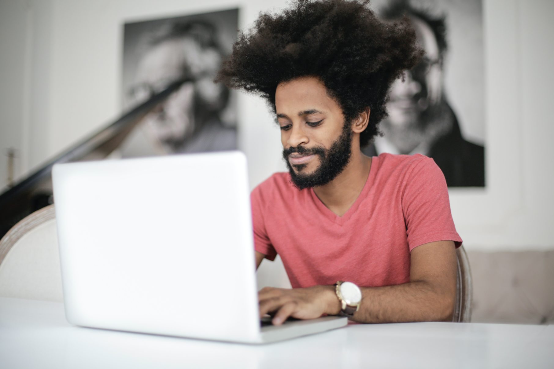 man in red t-shirt working on laptop