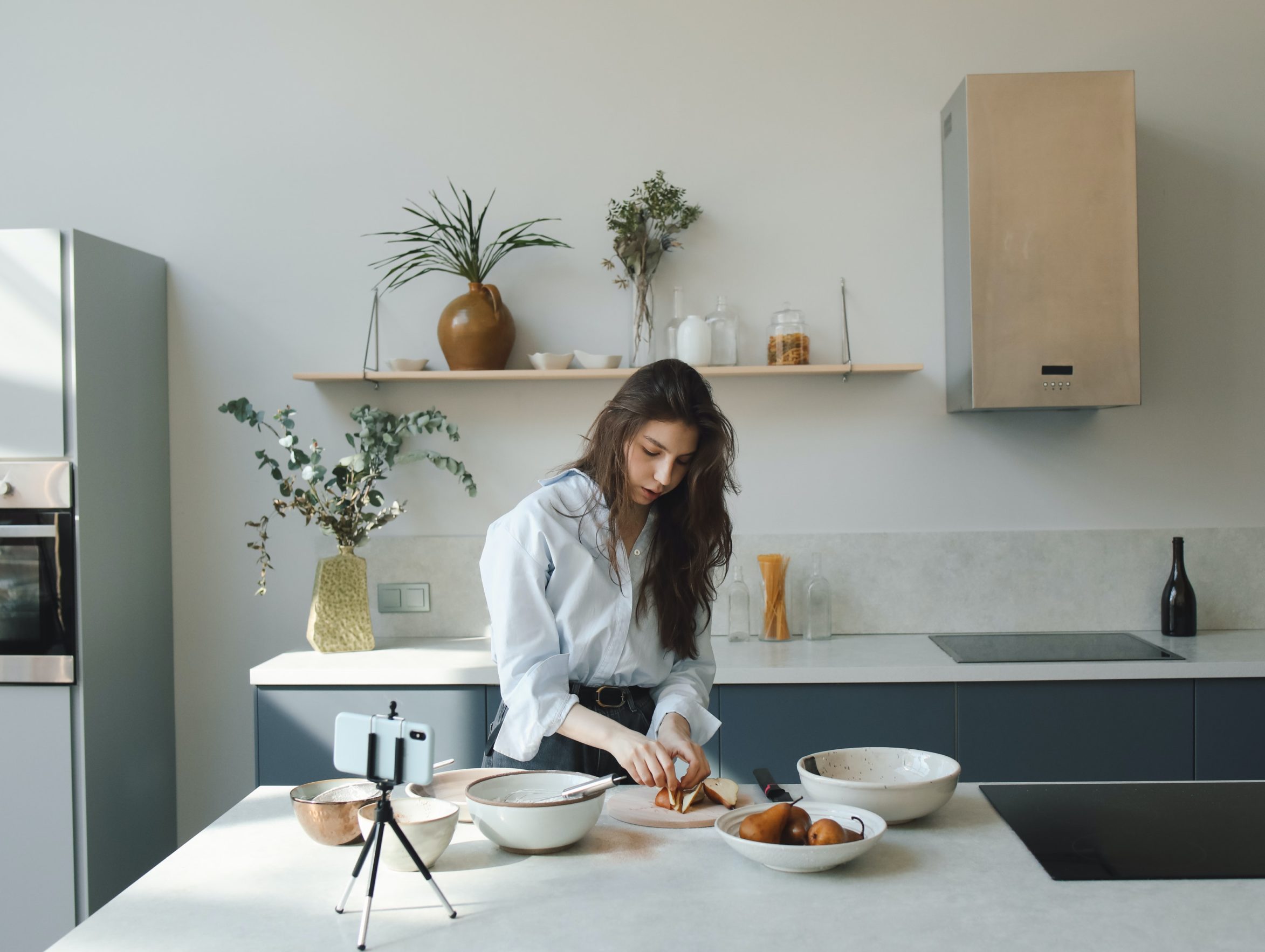 woman in kitchen filming on phone