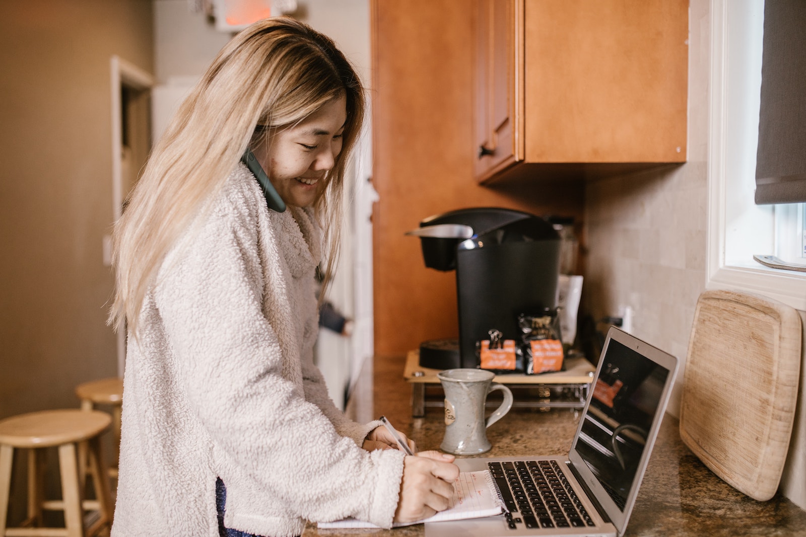 woman on computer and phone at home