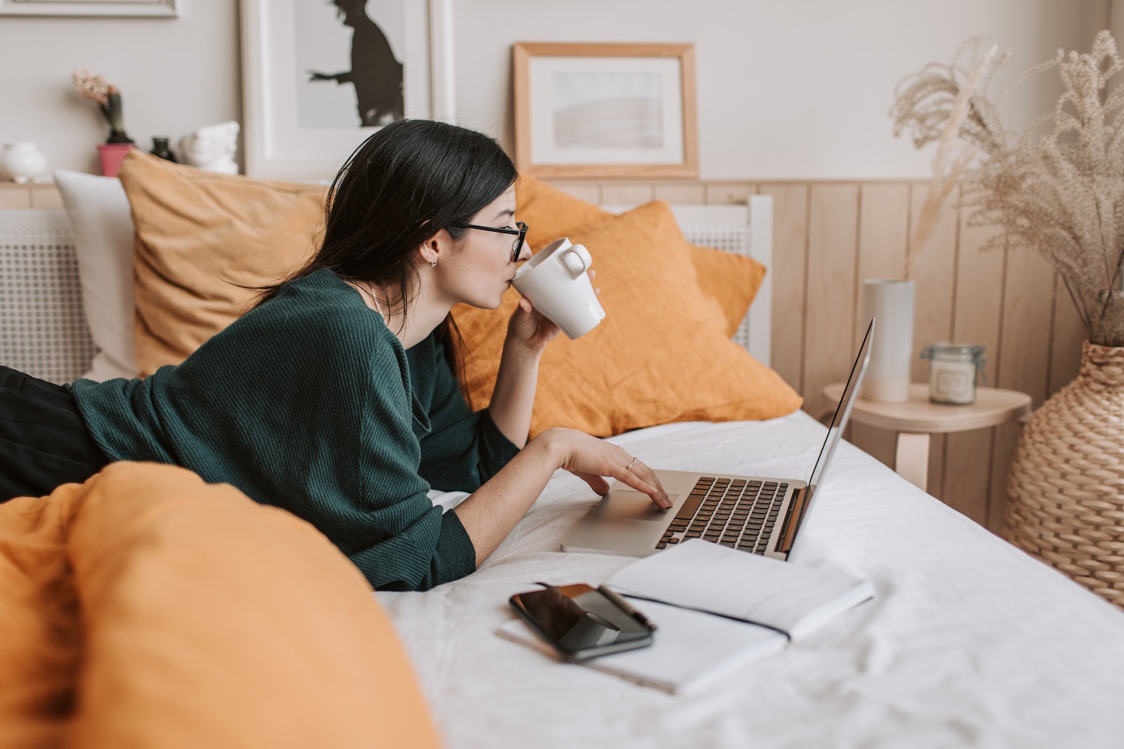 woman working on laptop from bed