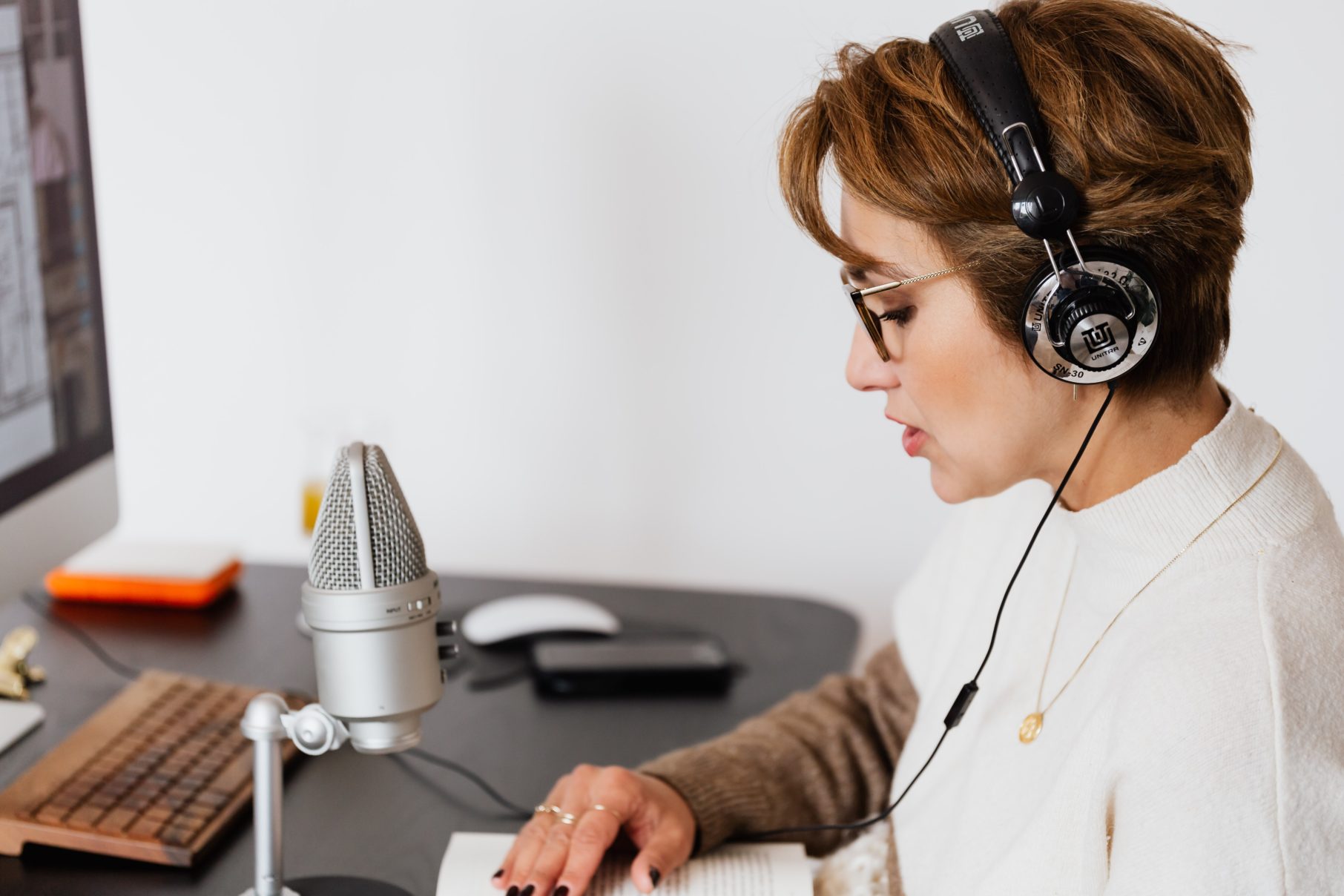 woman using headphones and speaking into microphone home studio equipment