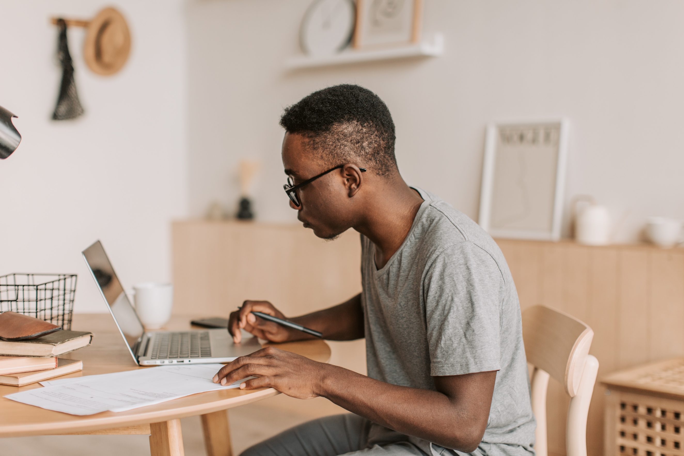 man sitting at desk while using laptop