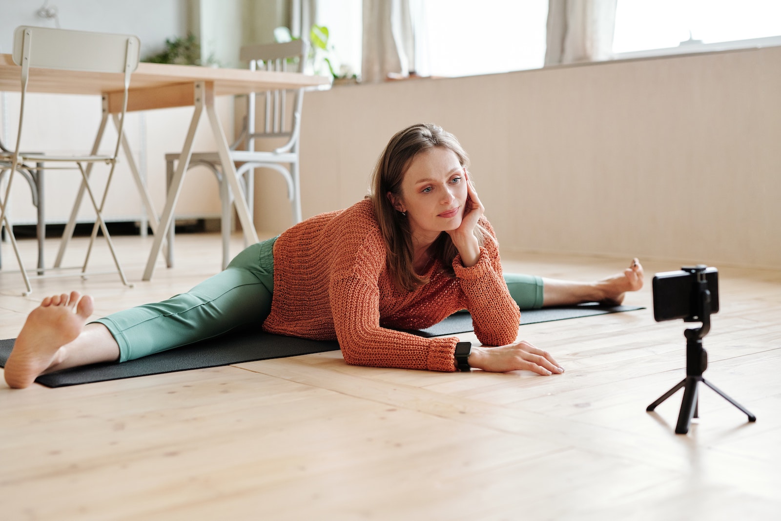 person filming yoga on phone