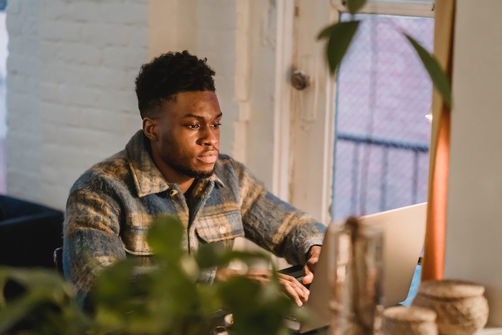 a person sitting and writing on a laptop